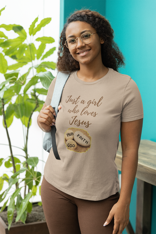 smiling woman posing wearing a backpack wearing a tee that reads-Just a girl who loves Jesus- tee, Christian tshirt, Bible gift, gift for mom, birthday gift, Faith tee, Inspirational women's tshirt, Jesus shirt, many colors available