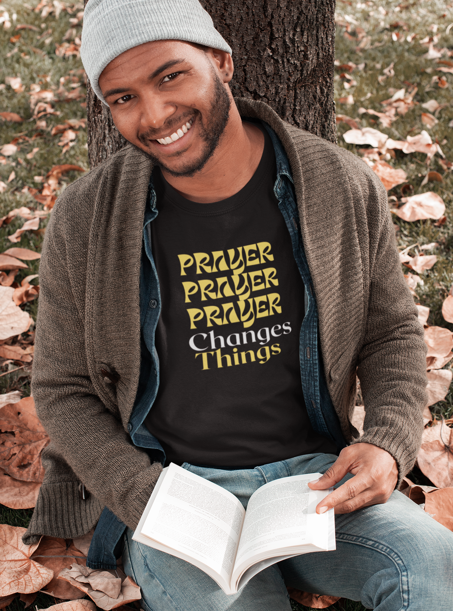 smiling man sitting leaning on tree and  has a book in hand and wearing tee that reads-Prayer Changes Things- Christian prayer tee, Inspirational t-shirt, motivational tshirt, mental health awareness, see matching mug, many colors available